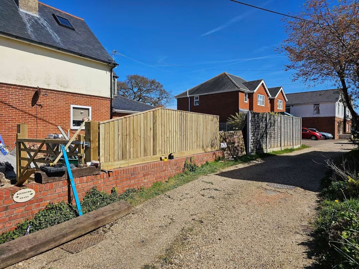 New closeboard fence panels fitted on top of a brick wall with a new gate