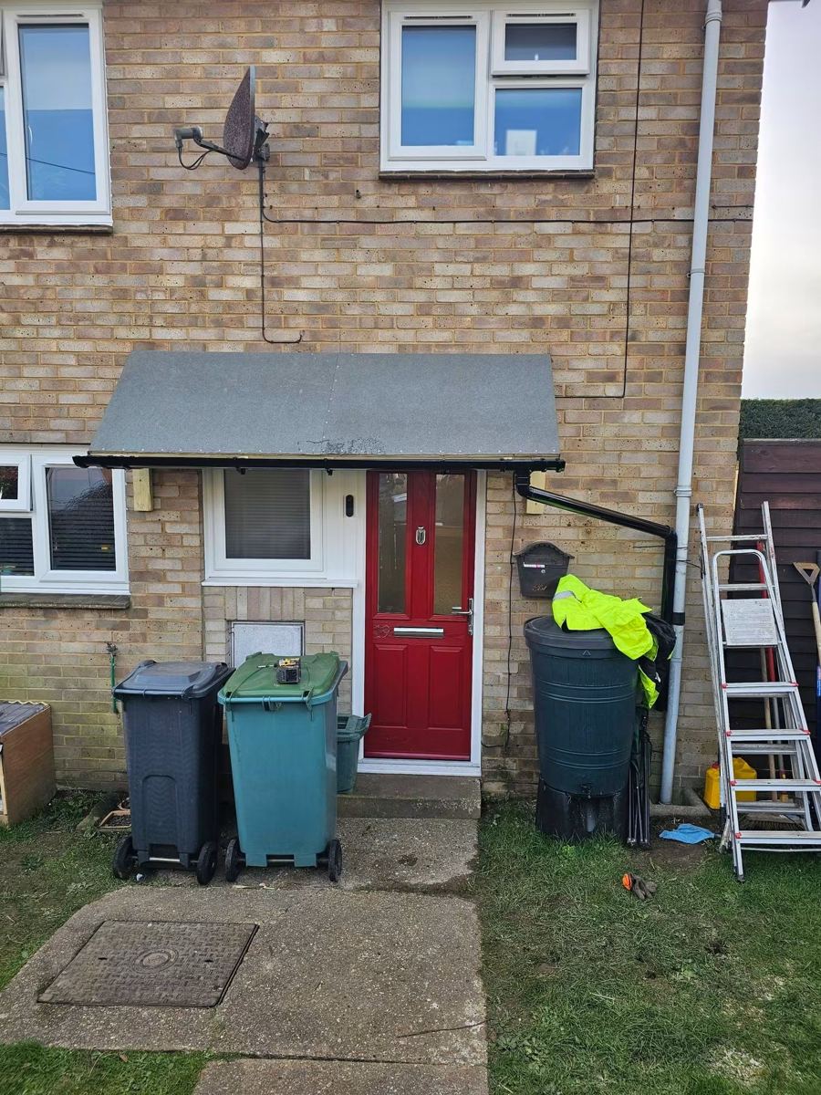 Porch canopy and guttering above a red front door